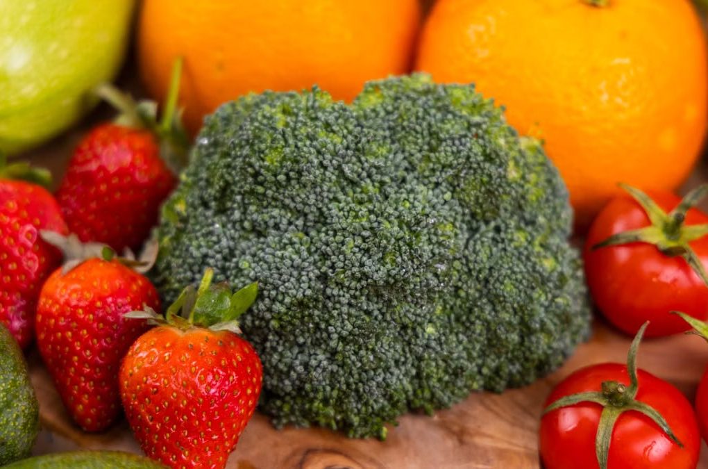 A vibrant collection of fresh, organic fruits and vegetables on a wooden table, showcasing healthy variety.